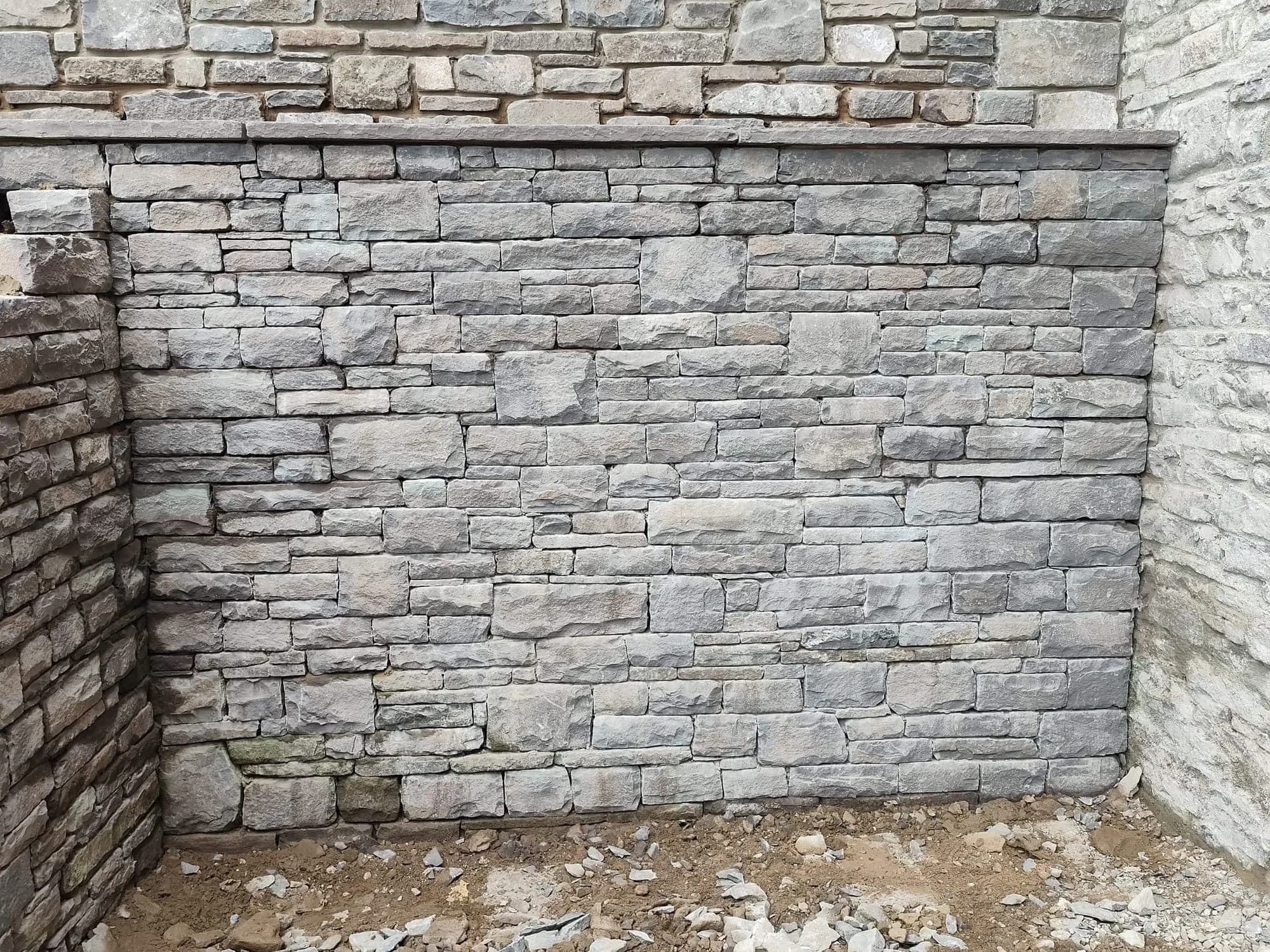 A newly built grey stone wall, pointed and finished
